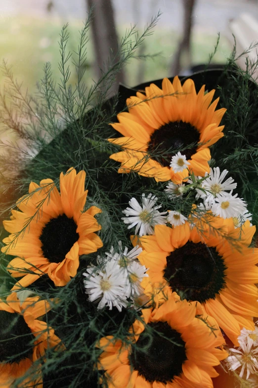 a table is holding a large bowl full of sunflowers