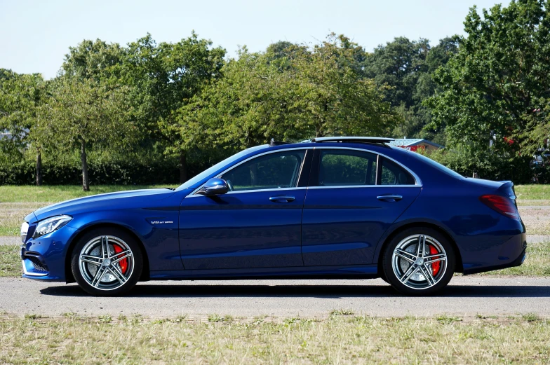 a blue car parked in front of some grass