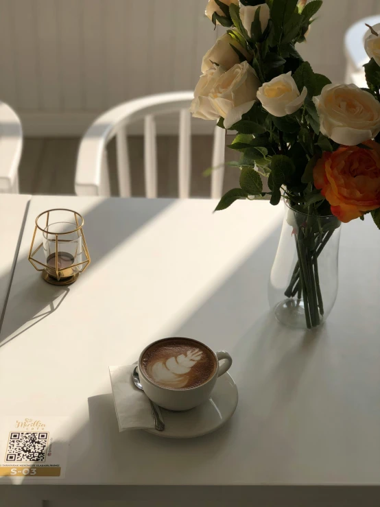 the cup of coffee has a small saucer with cream