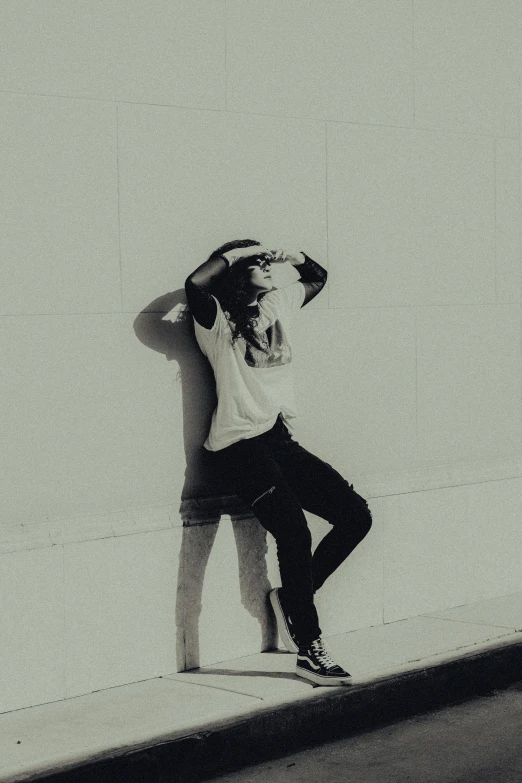 a boy is sitting on his skateboard looking down