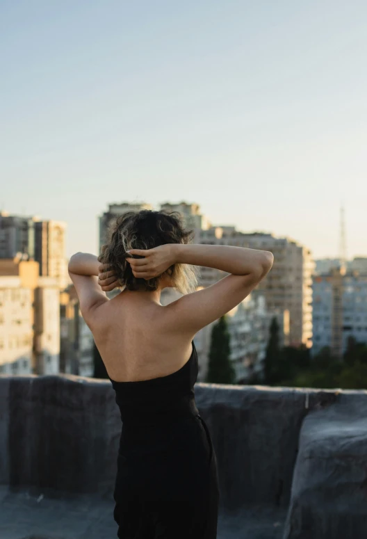 a girl in a black dress looking over her shoulder