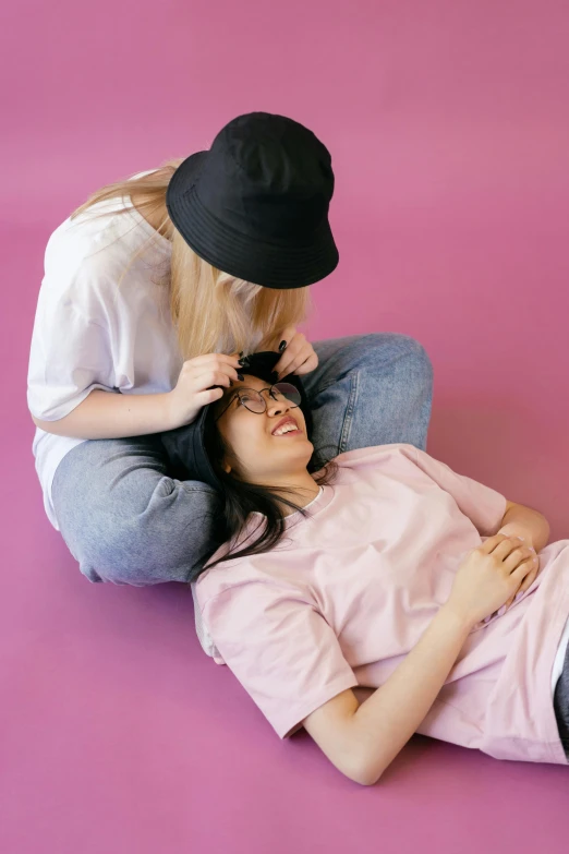 a woman lying on the ground with a hat and a black hat on her head