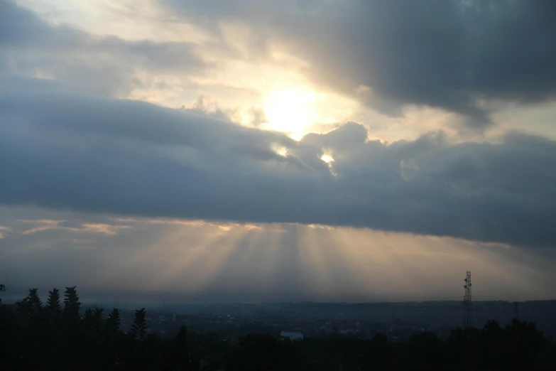 sun beams fill the sky over a large city