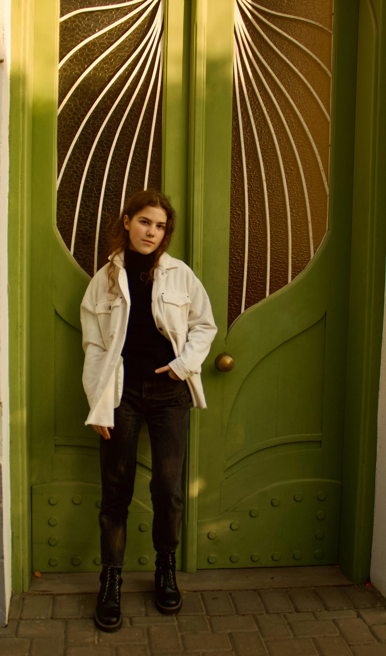 a woman standing in front of a green door