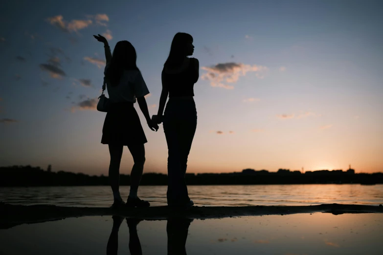 two silhouettes of two people holding hands