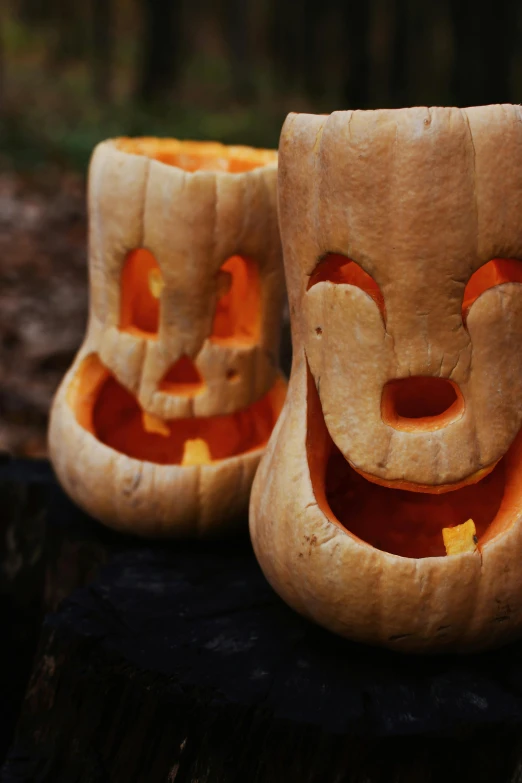 a pumpkin head statue sitting on top of a tree stump