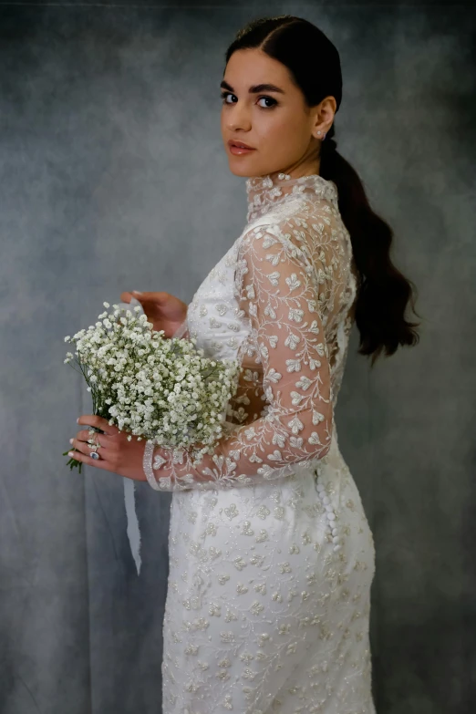 a woman in a white wedding gown holding flowers