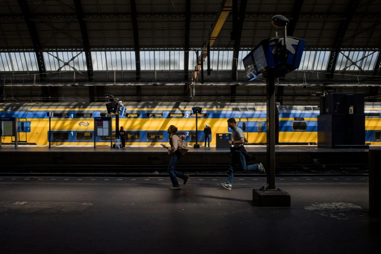 passengers are walking towards a subway train parked at a station