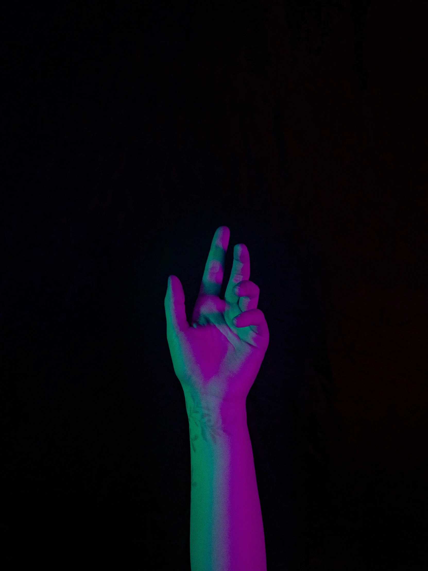 a person holds their hand up in the dark