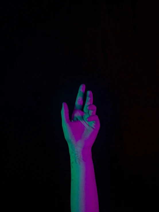 a person holds their hand up in the dark