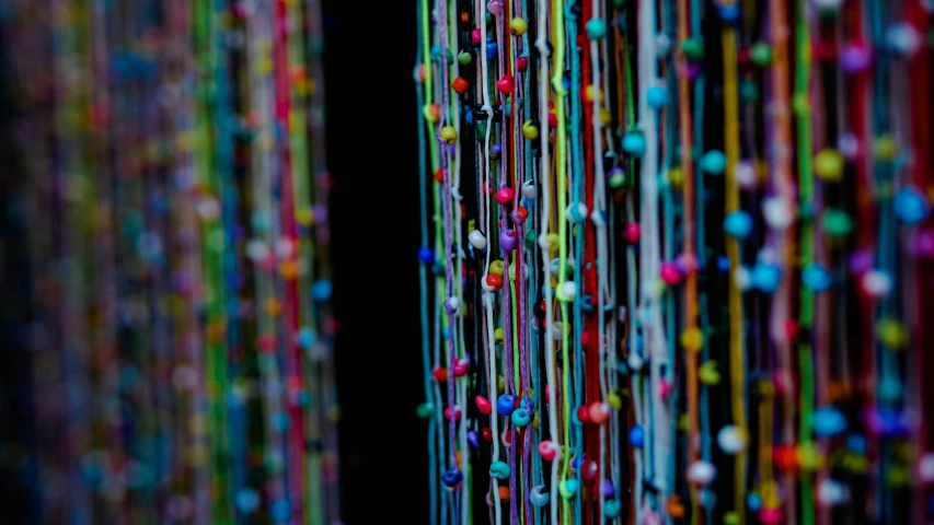 there is colorful beads hanging in a large window