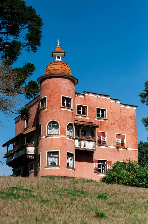 a building sitting on top of a lush green hillside