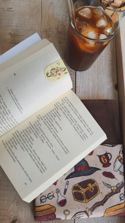 a table with an open book and two drink glasses on it