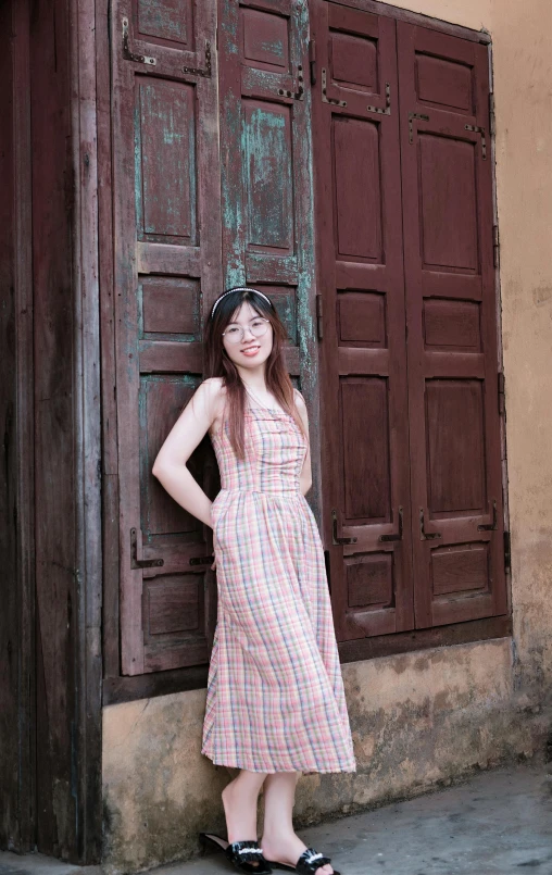 a woman wearing sandals standing in front of a window