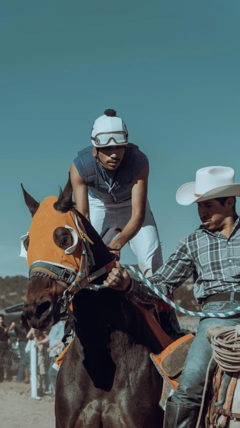 two men are riding horses on a dirt path