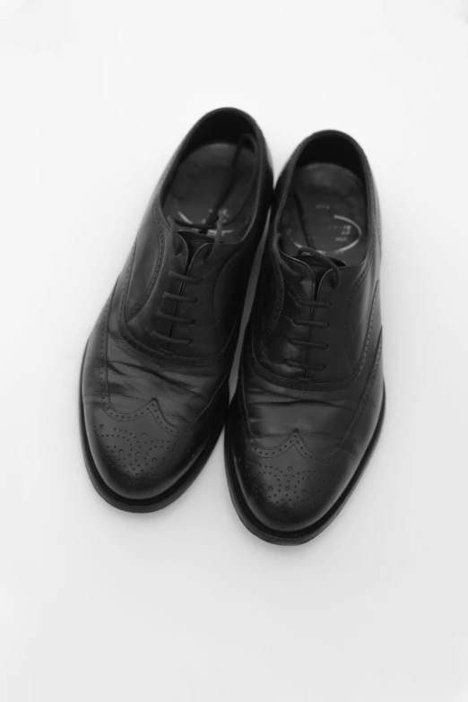 a black pair of shoes on top of a white background