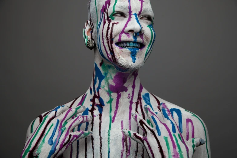 a man is covered with colorful lines and paint