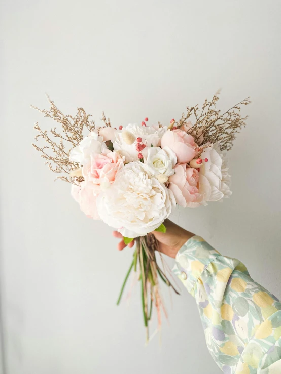 a flower bouquet held up on a woman's hands