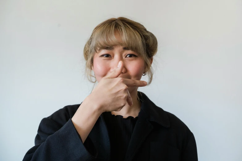 a woman is posing with her finger on her mouth