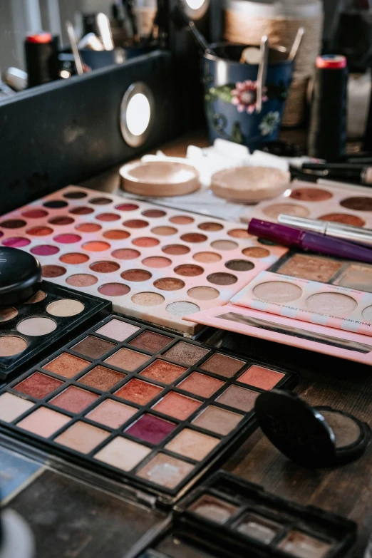 several different makeup products in one pile on top of the table