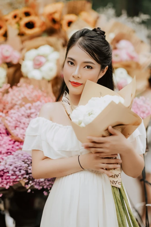 a woman in white holding flowers and a large bouquet