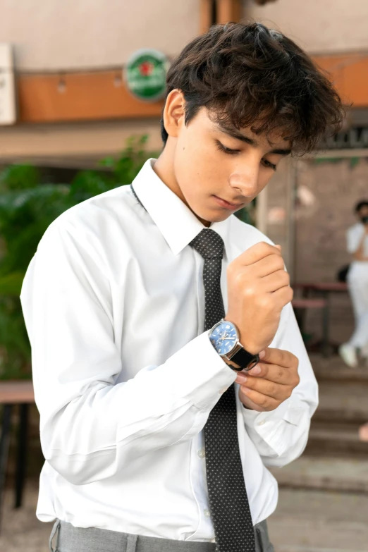 a young man wearing a tie is putting on his tie