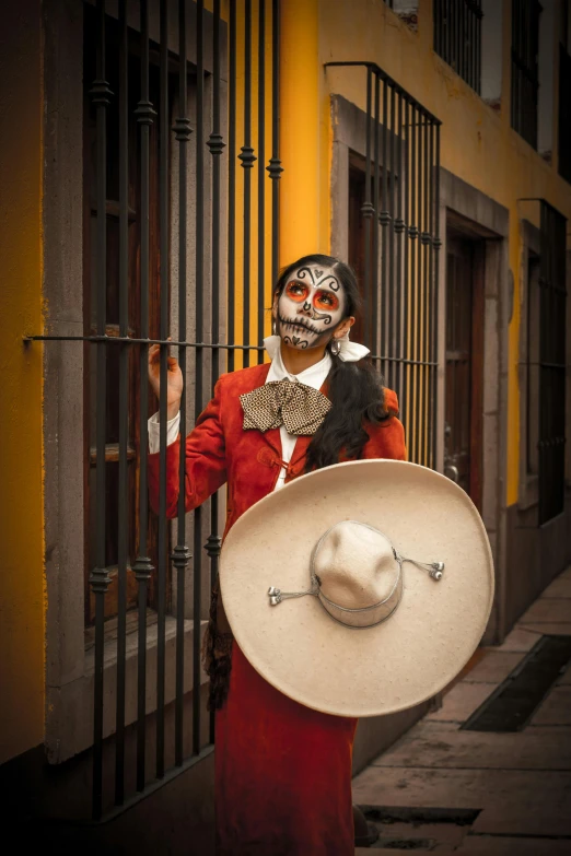 man in scary face makeup and hat next to gate