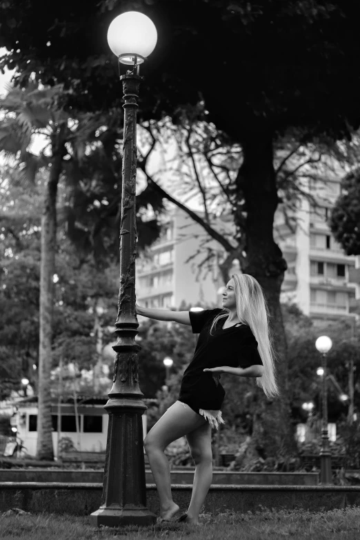 a woman that is standing near a street light