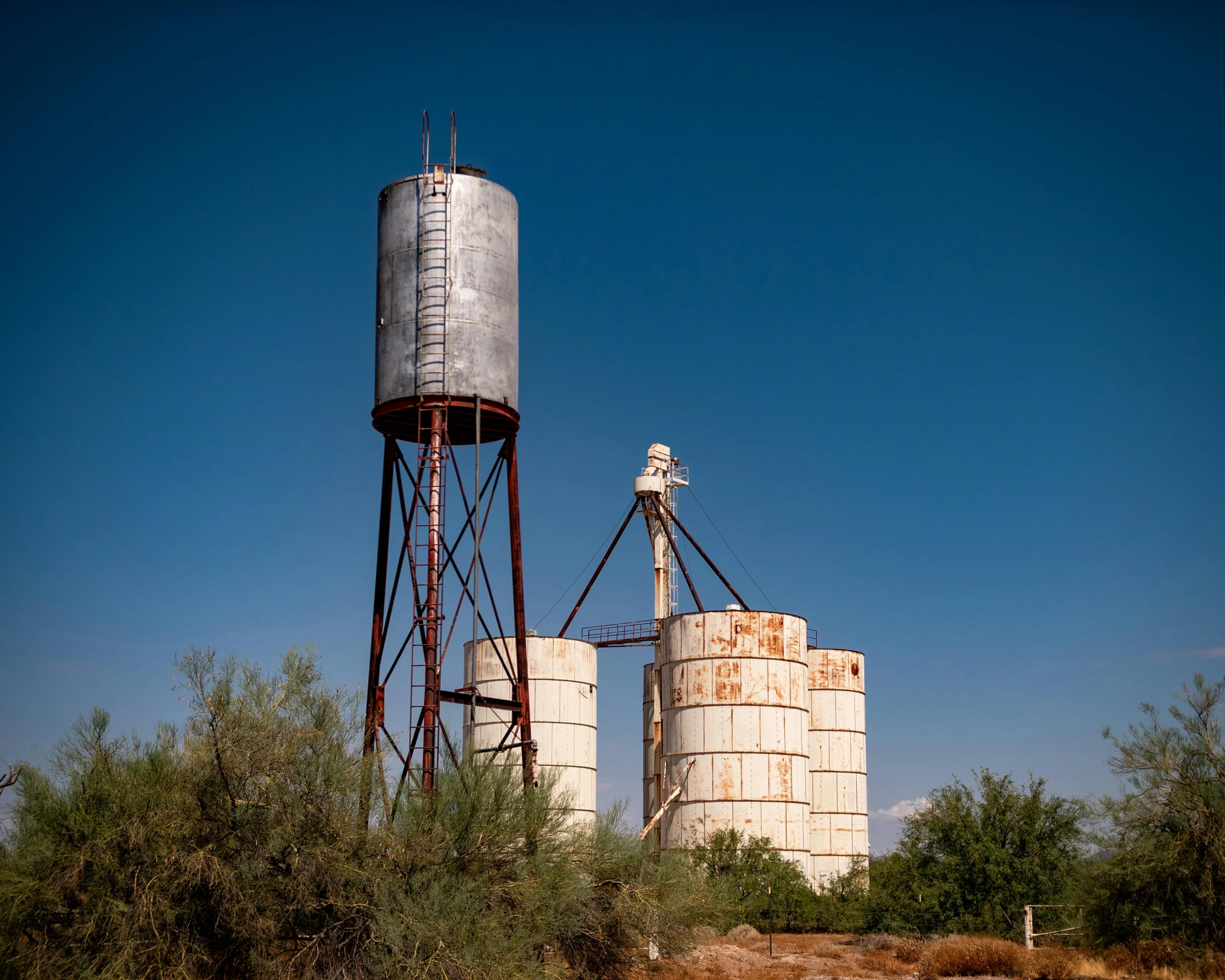 two large water tanks sitting in the middle of a desert