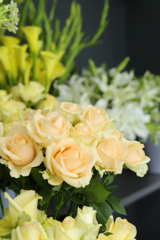 two large vases filled with yellow and pink roses