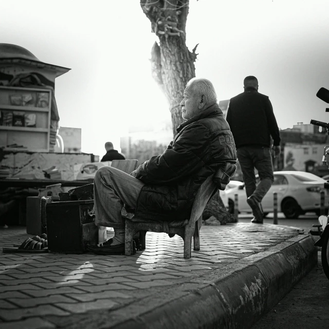 a woman sitting on a bench next to a luggage bag