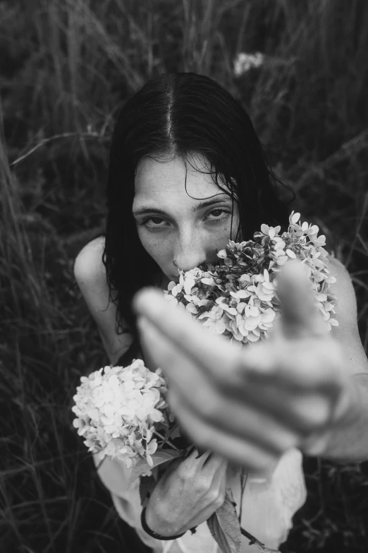 a woman is holding flowers by her face