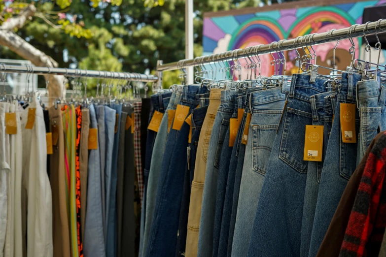 a bunch of jeans that are on a rack