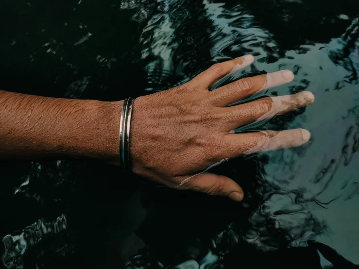 a person wearing two thin rings, on their hand