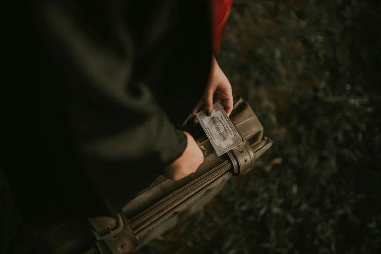 a person is holding a suitcase containing cards