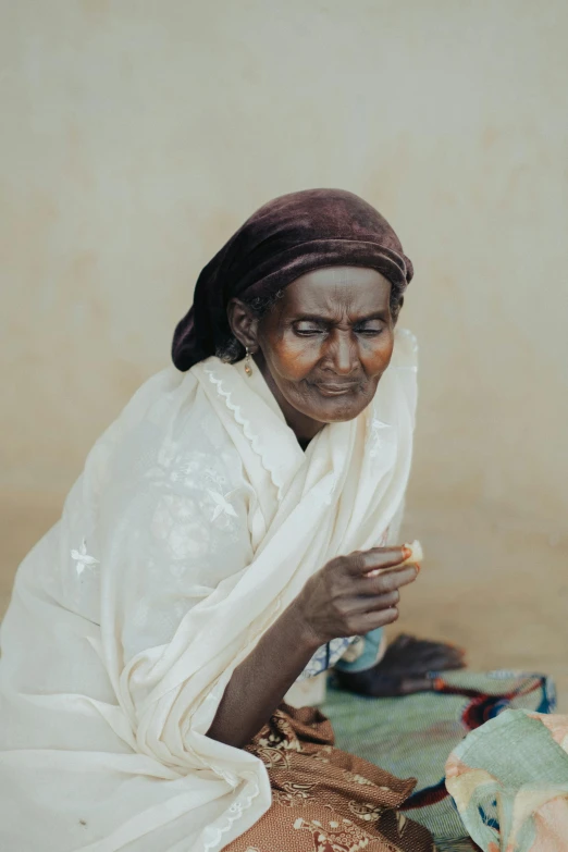 an old woman is sitting in her clothes