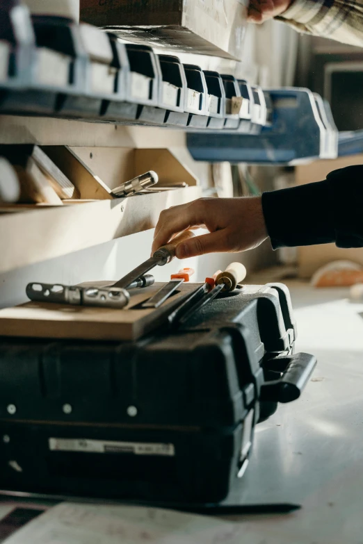 a person placing soing onto a black luggage