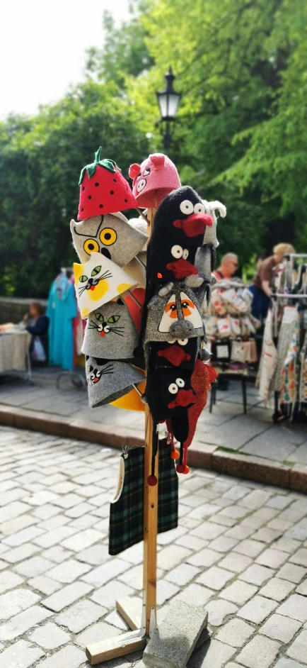 a pile of hats sitting on top of a wooden stand