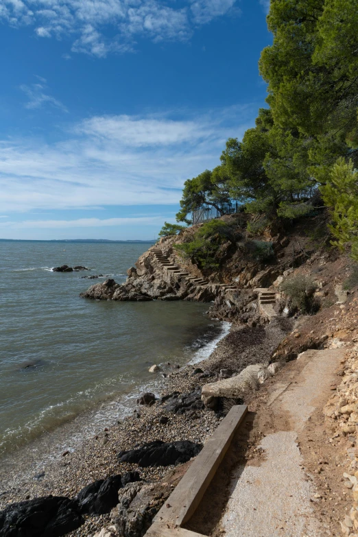 a long bench by the beach is empty