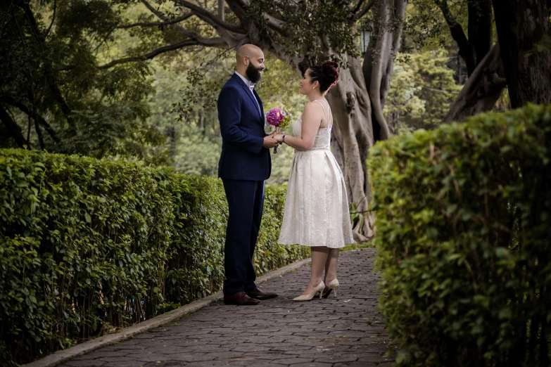 the bride and groom stand next to each other while holding flowers