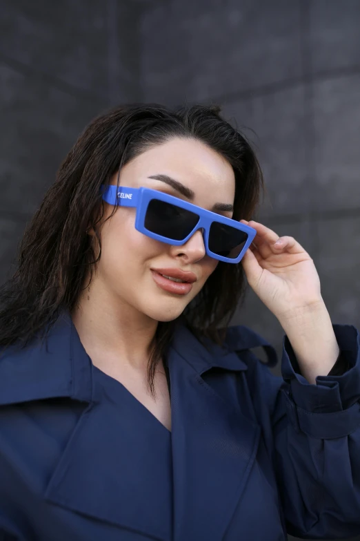 the girl is wearing blue sunglasses with a pair of black glasses