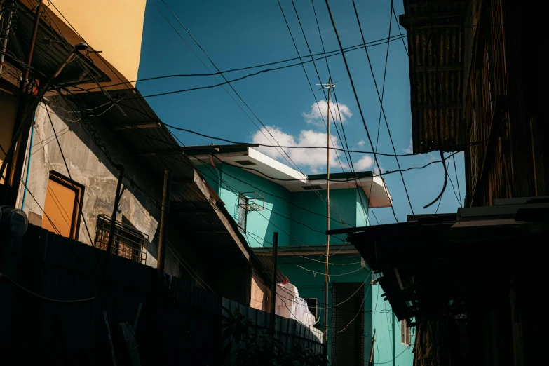 a street view of buildings in an alleyway with wires above