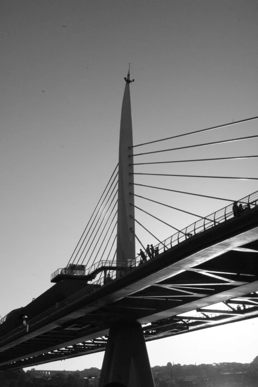 a black and white po with a bridge in the background