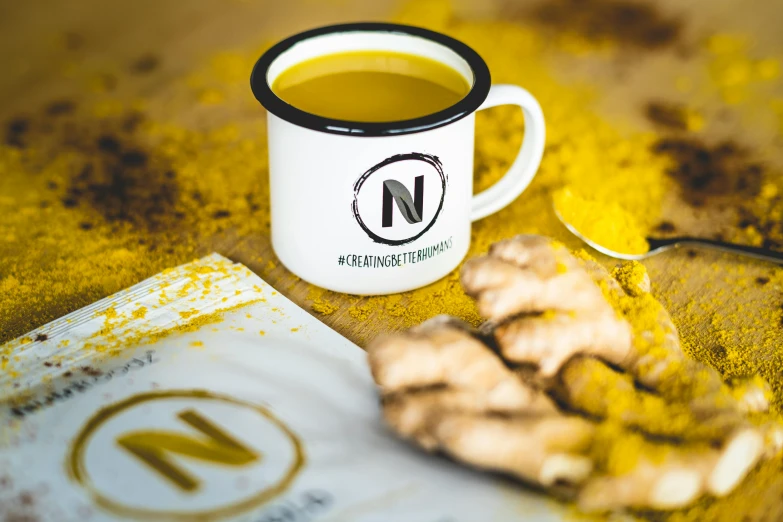 a mug of tea sitting next to a spoon on a table