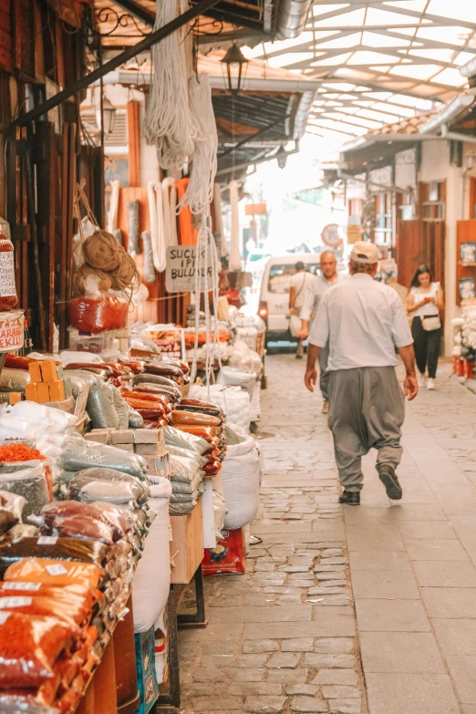 a man walking down a street surrounded by a covered market