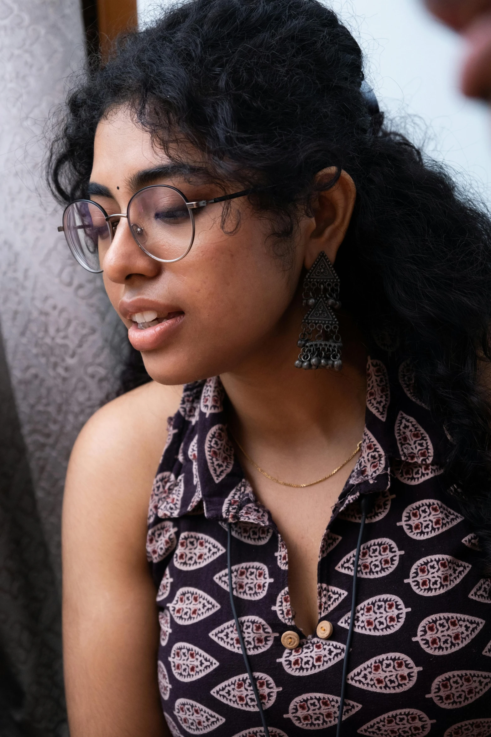 a woman wearing glasses with a necklace on