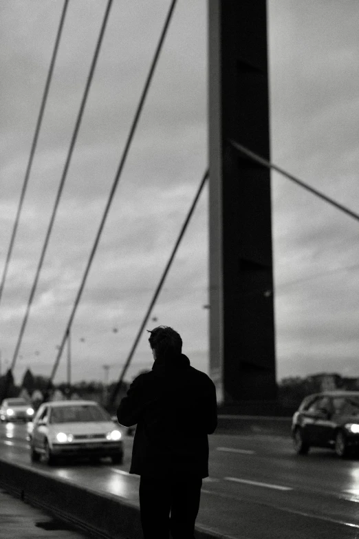 a man with coat walking near street next to traffic