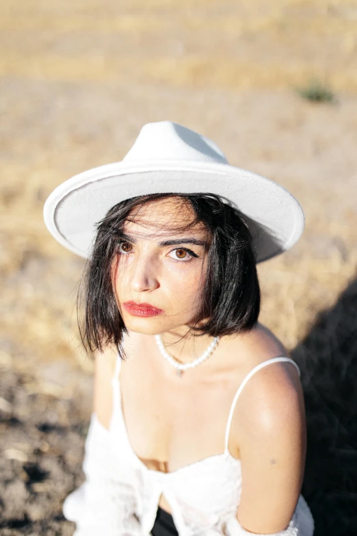 a woman in a white dress wearing a hat