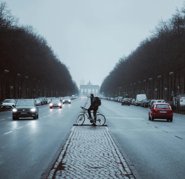 a man riding his bicycle down the middle of a street