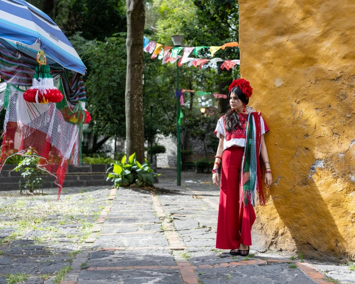 a woman is standing by a stone building